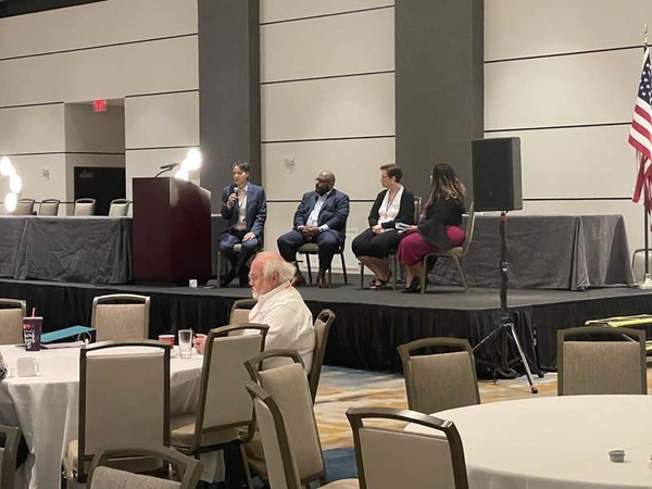 ChallengesWeFaceinHousingPanelistsDr.TonyWhiteMDHAandLisaOsankaLousivilleMetroHAOption2.jpg A panel of four speakers are sitting on a stage in a large conference room.