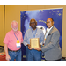 Three men holding an award.