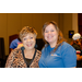 Two women standing side by side while smiling.