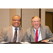 Two men in suits smiling for a photo.