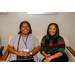 Two women sitting together on a sofa.