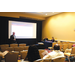 A man standing next to a projector screen giving a presentation.