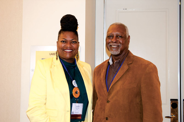 A man and a woman standing side by side posing for a photo.