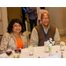 A man and a women sitting at a table with a white table cloth.