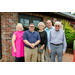 Five individuals posing for a photo outside.