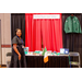 A woman posing in front of her booth.