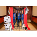 Three women standing behind jail bars at a photo booth station with various Monopoly game props.