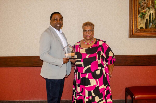 A man and a women posing with one of the SERC-NAHRO awards.