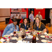 Three women at a dinner table with display booths in the background.