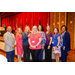 President Anthony posing with a group of women in front of the stage.