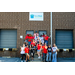 A big group of individuals doing fun and silly poses outside of the Back Pack Beginnings building.