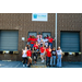 A group of individuals in front of the Back Pack Beginnings building while posing for a photo.