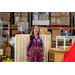 A woman standing inside a warehouse speaking to a group.