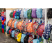 Backpacks of all shapes and colors hanging on a display.