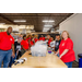 A group of individuals posing around a table full of school supplies.