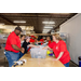 A group of individuals having fun while packaging school supply gift bags.