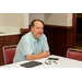 A man sitting at a table smiling for the camera.