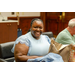 A woman in a blue shirt smiling big for the camera.