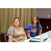 Two woman turned to the side in their chairs listening to someone speak off camera.