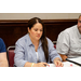 A woman in a blue and white striped shirt looking done at some documents on a table.