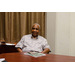 An individual sitting comfortably in his chair while smiling for the camera.