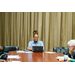 An individual at the end of the table listening to those around her.