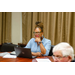 A woman thinking pensively about the conversation going on at the table.