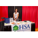 A woman posing with her booth for HSA: Housing Solutions Alliance LLC.