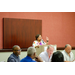 A woman speaking at the podium while gesturing with her hands. 