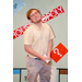 A man holding Housingopoly money in front of himself while he poses with the Housingopoly game board backdrop.