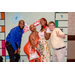 A group of four making fun and silly poses with the Housingopoly game board backdrop.