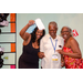 Three individuals in the Housingopoly game board photo booth with one individual throwing Housingopoly money in the air.