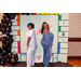 Two women standing with their backs to each other in the Housingopoly game board photo booth.