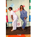 Two women standing with their backs to each other, with one woman sticking her butt out to the other while in the Housingopoly game board photo booth.