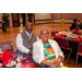 A woman and a man sitting at a dining table smiling big for the camera.