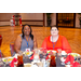 Two women sitting at a dinning table.