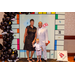 President Anthony Goodson, Jr. posing with a woman and a child inside the Housingopoly game board photo booth.