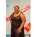 A woman in a black dress and glasses posing with the Housingopoly game board backdrop.