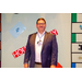 A man posing with the Housingopoly game board backdrop.