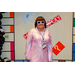 A woman in 70s fashion with big white sunglasses posing in the Housingopoly game board photo booth.