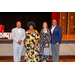 President Anthony Goodson, Jr. posing with three other individuals in front of the stage.