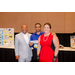 President Anthony Goodson, Jr. posing with two other individuals in front a of table with poster displays and gift baskets.