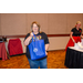 A woman in a Kiss rock band t-shirt holding a blue gift bag.