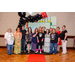 Twelve individuals posing for a group photo in a Housingopoly board game photo booth.