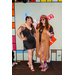 A woman in a 1920s flapper dress and a women in 70s fashion posing in the Housingopoly game board photo booth.