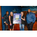 Four individuals standing next to a poster that says After Hours Welcome Party.