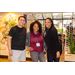 A man and two women smiling for a group photo in a lobby.