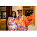 Two women in floral shirts smiling big for a photo.