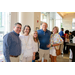 Five individuals taking a group photo in a brightly lit lobby.