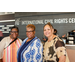 Three individuals posing with the logo of the International Civil Rights Center and Museum.